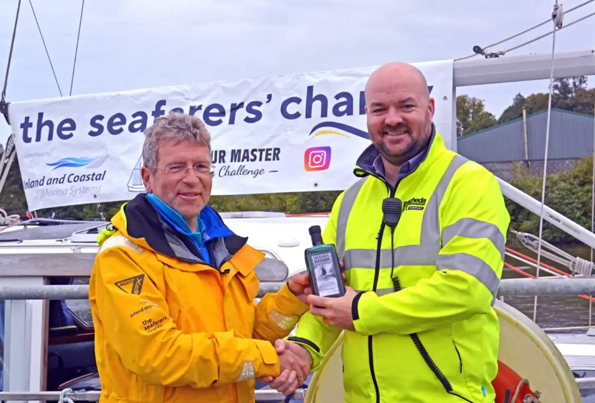 Captain Laurence Kirwan, harbour master at Drogheda presents Mark with a bottle of Aleria Beacon Gin to mark the completion of his challenge