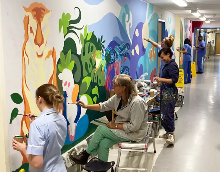 Staff working on the new mural on Kingfisher Ward at Dorset County Hospital