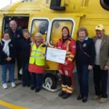 Lions president Janet Godden presenting the cheque to critical care practitioner, Lauren Dyson, alongside other group members