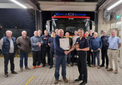 Chief fire officer Ben Ansell with Phil, surrounding by colleagues past and present. Picture: Blandford Fire Station