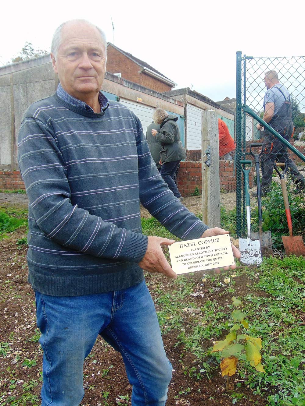 Blandford Allotment Society chairman Ian Ricketts displays the plaque commemorating the planting