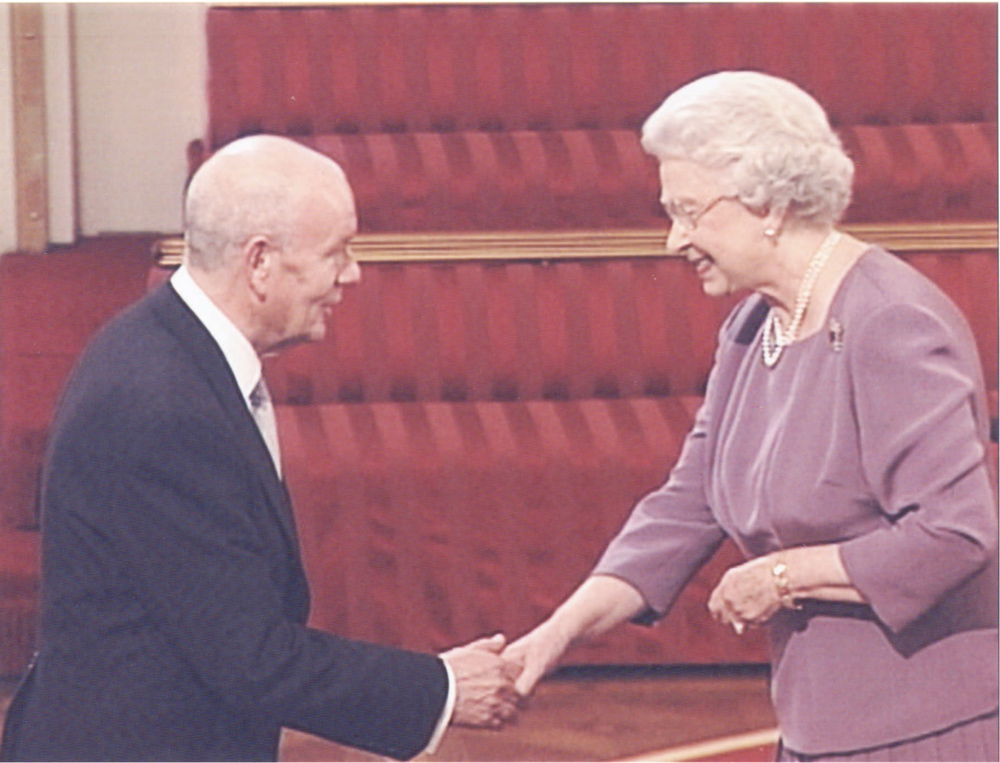 Queen Elizabeth shaking hands and placing medal