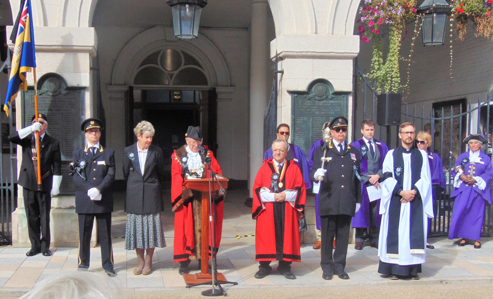 The Mayor of Blandford Colin Stevens reads the Proclamation with, left to right, RBL standard Bearer Tony Lucas, deputy Mace Bearer James Watling, Mayoress Chris Stevens, Deputy Mayor Hugo Mieville, Mace Bearer David Jardine, and Mayor’s Chaplain Chris Beaumont, and behind other town councillors and Deputy Town Crier Liz Rawlings;